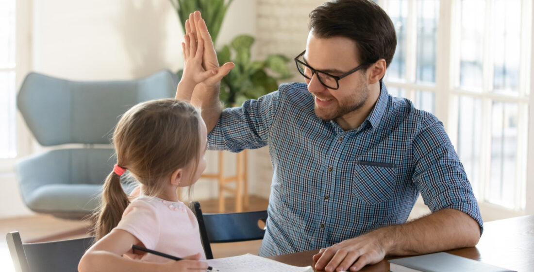 tutor giving a high five to young girl during tutoring session