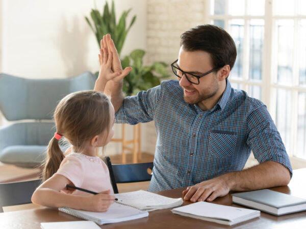 tutor giving a high five to young girl during tutoring session