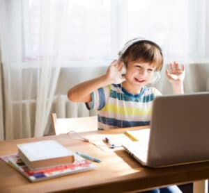 a happy young boy participating in his online classes