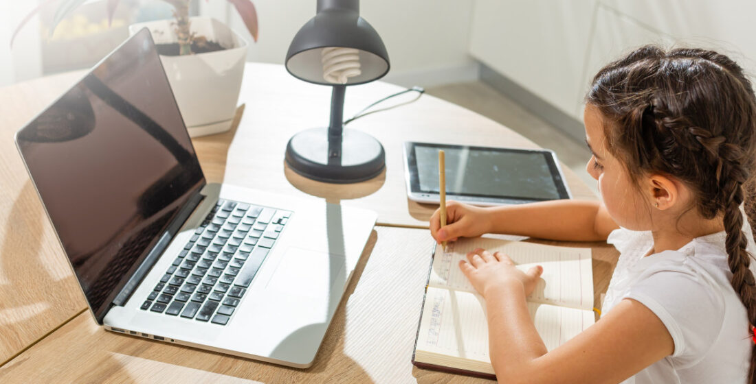 young girl learning remotely with a tutor