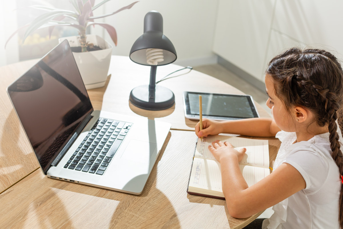 young girl learning remotely with a tutor